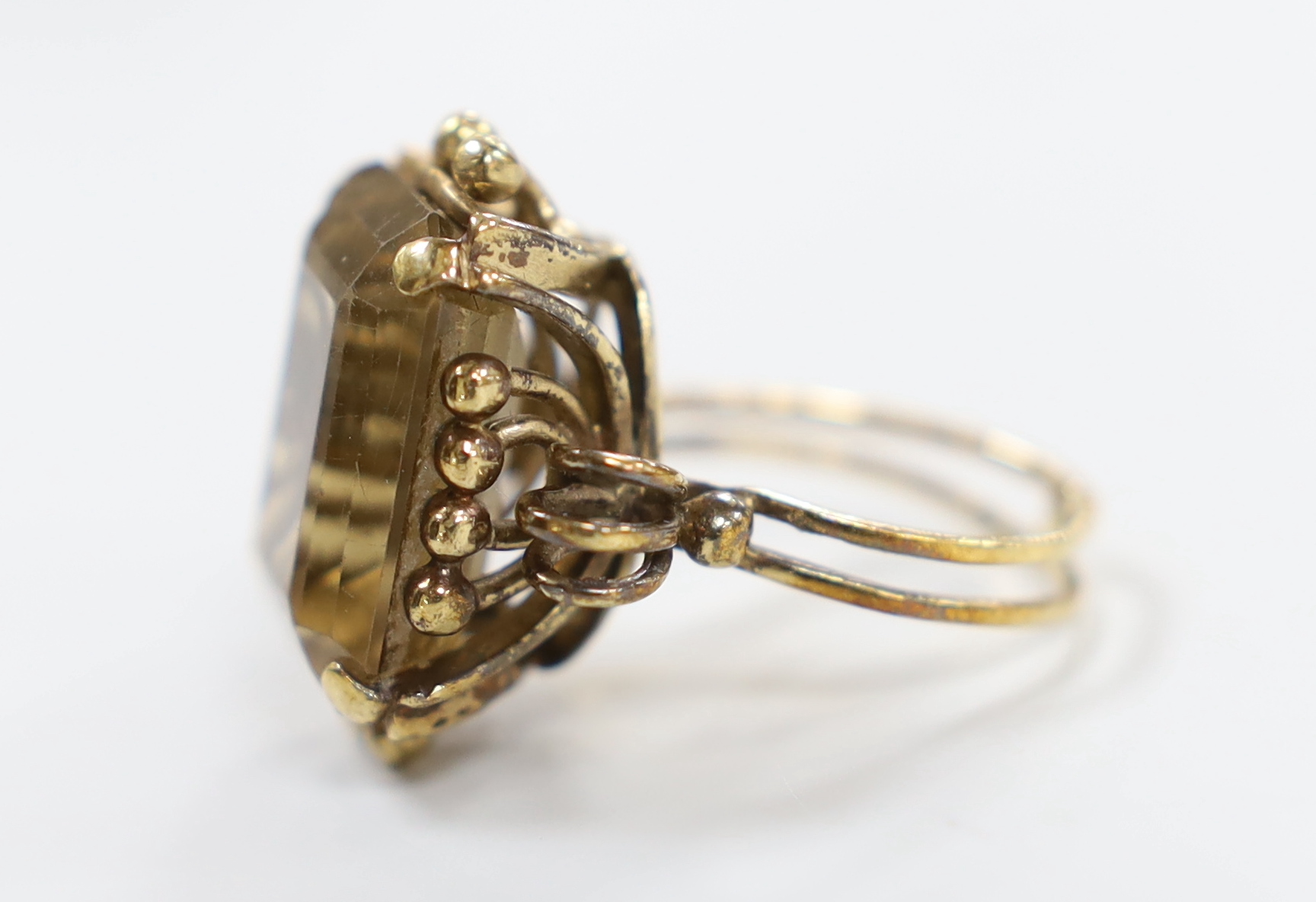 An early 20th century yellow metal and emerald cut citrine set dress ring, size R/S, gross weight 12 grams.